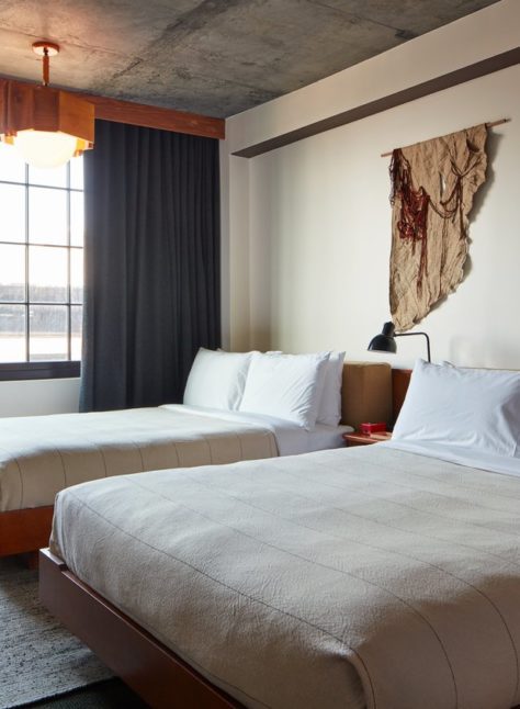 A room with modern styling and hanging light fixture suspended from a concrete ceiling