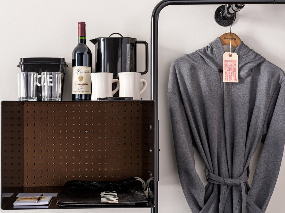 A desk provides space to work and has an ice bucket, kettle and wine for consumption